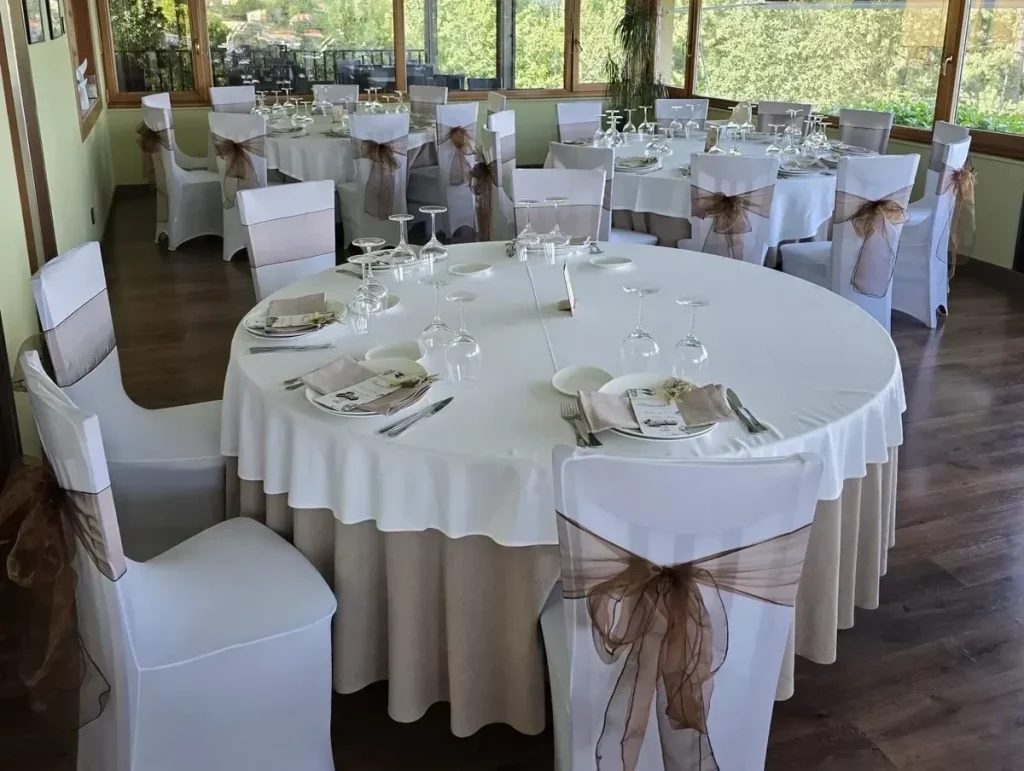 Mantelería blanca redonda con faldón color lino y fundas para sillas instalada por Currás y Salgado en el Restaurante El Pinar de Perbes, A Coruña.